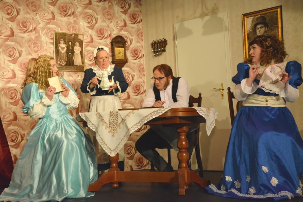 Zwei Frauen in Ballkleidern, eine Hausangestellte mit Teekanne und ein Mann sitzen am Tisch